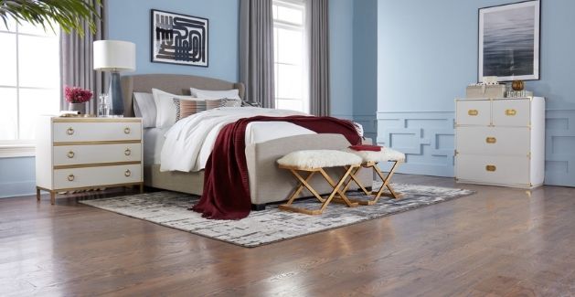 medium brown hardwood floors in a chic bedroom with light blue walls